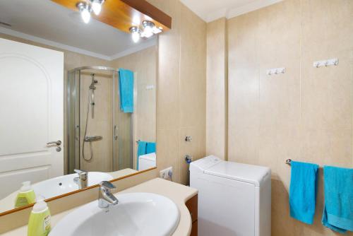 een badkamer met een wastafel, een toilet en een spiegel bij Pineda H in Arguineguín
