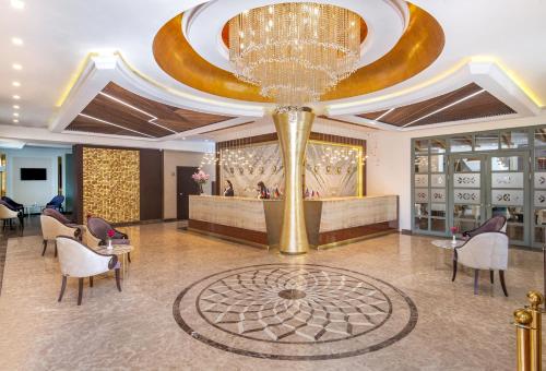 un vestíbulo con una gran lámpara de araña de oro en un hotel en Hotel National, en Ereván