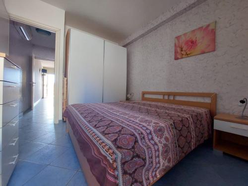 a bedroom with a bed and a dresser in it at Bilocale per l'affitto estivo in Torre Pali