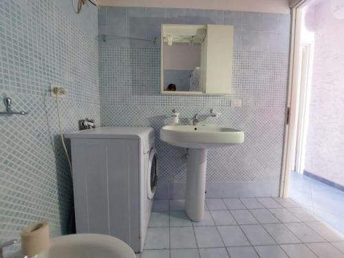 a white bathroom with a sink and a toilet at Bilocale per l'affitto estivo in Torre Pali