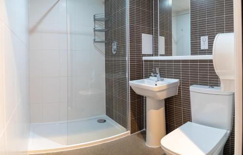 y baño con aseo, lavabo y ducha. en Safestay Edinburgh Cowgate, en Edimburgo