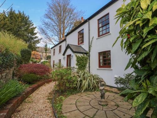 an exterior view of a white house with a garden at The Laurels Flat in Cardiff