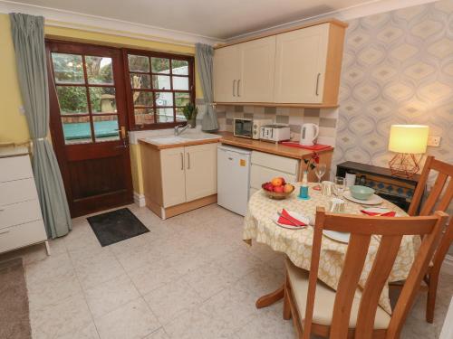 a small kitchen with a table and a table and chairs at The Laurels Flat in Cardiff