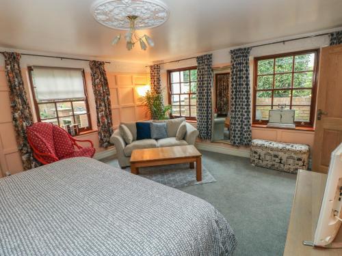 a bedroom with a bed and a chair and a couch at The Laurels Flat in Cardiff