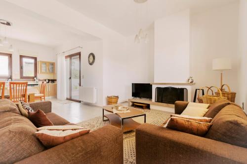 a living room with a couch and a tv at Alonia View House in Asklipiḯon