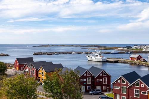 a boat is docked in a harbor with houses at Rorbu i Bud Havn in Bud