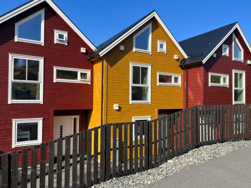 a row of colorful houses behind a fence at Rorbu i Bud Havn in Bud