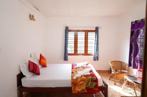 a bedroom with a bed and a window at Misty Hills Munnar in Munnar