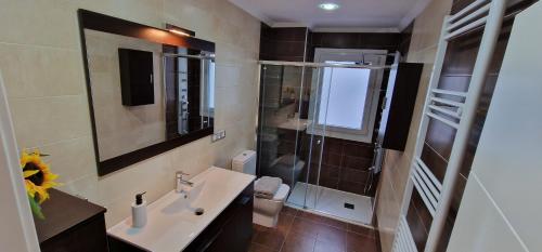 uma casa de banho com um lavatório e uma cabina de duche em vidro. em Astur Playa I - WiFi · 2 Hab · 2 Baños · 4 pax em Gijón