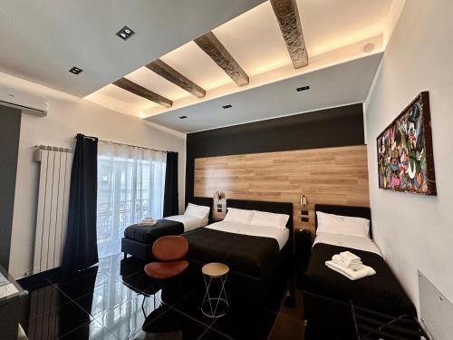 een hotelkamer met twee bedden en een bank bij Elegance Rooms Spaccanapoli in Napels