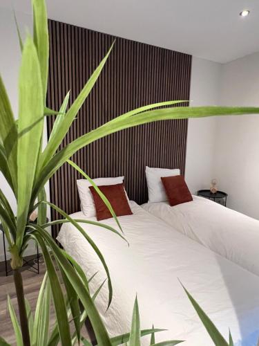 um quarto com duas camas e uma planta grande em Waterside Voorthuizen em Voorthuizen