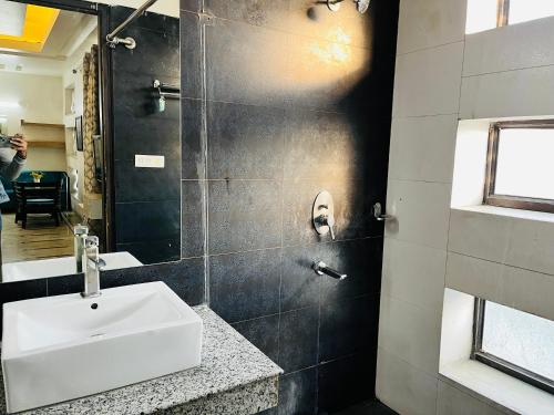 a bathroom with a sink and a mirror at Hotel Golden Saffron - Punjabi Bagh Delhi in New Delhi