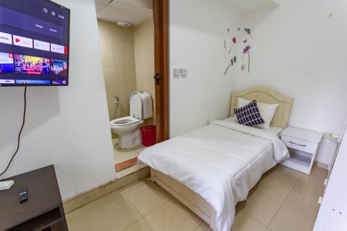 een slaapkamer met een bed en een badkamer met een tv bij Wonderful Master Rooms For Girls ONLY in Marina, Dubai in Dubai