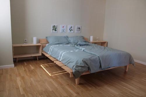 uma cama num quarto com duas mesas de cabeceira e uma cama sidx sidx em Sunny Center Apartment em Skopje