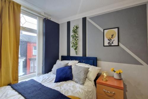 a bedroom with a blue and white bed and a window at Great Liverpool Location! in Liverpool