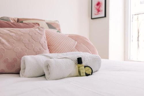 a towel laying on a bed with a bottle of soap at GuestReady - Amazing Studio near Disneyland in Montévrain