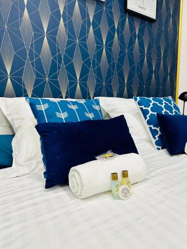 a bed with blue and white pillows and towels at GuestReady - Amazing Studio near Disneyland in Montévrain
