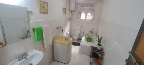 a white bathroom with a sink and a toilet at Mendrelgang Homestay in Punākha