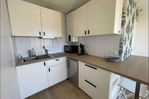 une cuisine blanche avec des armoires blanches et un évier dans l'établissement Studio for 4 people near the beach with air conditioning, à Palavas-les-Flots