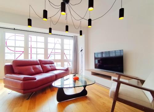 a living room with a red couch and a glass table at Arq Plaza Mayor in Viveiro