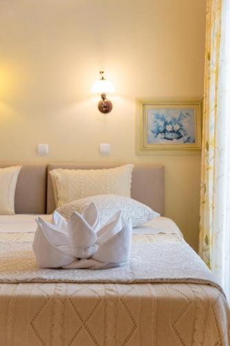 a white bed with a white flower on it at Kymata Hotel in Naxos Chora