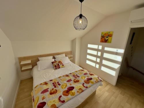 a bedroom with a bed and a pendant light at Gîte du Moulin- CLG Savoie - Vélo tourisme - 3CH - 2SDB 