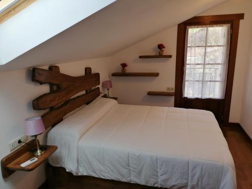 1 dormitorio con cama blanca y ventana en Casa rural SOROA landetxea en Arantza