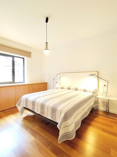 a bedroom with a bed with a striped bedspread at Arq Plaza Mayor in Viveiro