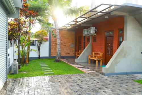 uma casa com um alpendre com uma mesa e um banco em Airport Colombo Pocket Paradise em Seeduwa