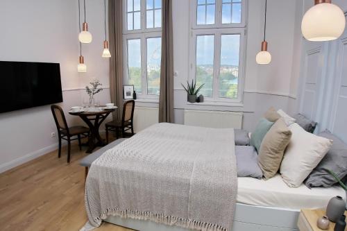 a bedroom with a bed and a living room with a table at Gellerico Apartments Deák Square in Budapest