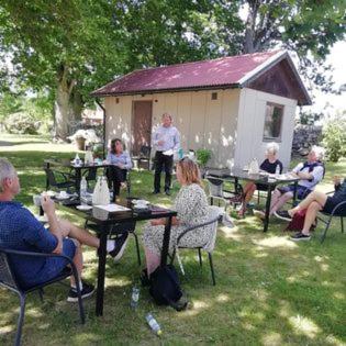 a group of people sitting at tables in the grass at Moshults Vandrarhem in Moshultamåla