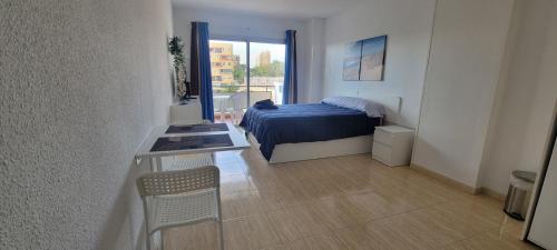 a bedroom with a bed and a table and a window at COMODORO- RAVEL in Los Cristianos