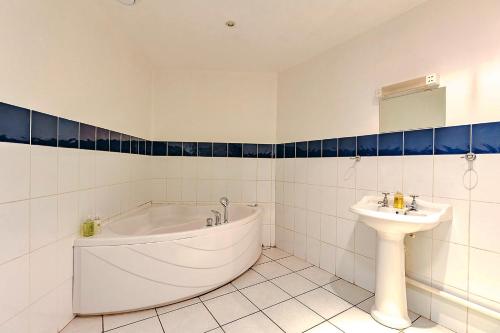a white bathroom with a tub and a sink at Finest Retreats - Netley Hall - Honeysuckle in Dorrington