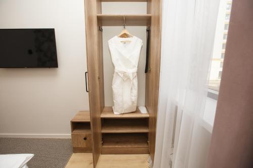 a white dress hanging on a door in a room at ASYL Hotel in Astana