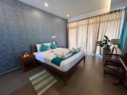 a bedroom with a bed with a blue wall at Sunset and Palm trees - An Airport Boutique by the Sea in Trivandrum