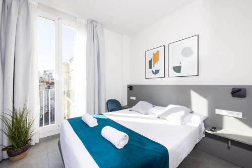 1 dormitorio blanco con 2 camas y ventana en Apartamentos Turísticos Plaza del Rey en Cartagena