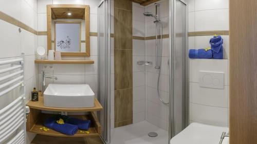 uma casa de banho com um chuveiro e um lavatório branco em Gästehaus Hillebrand em Bischofswiesen