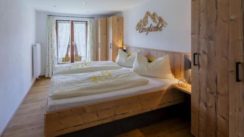 ein Schlafzimmer mit einem Holzbett und einem Fenster in der Unterkunft Gästehaus Hillebrand in Bischofswiesen