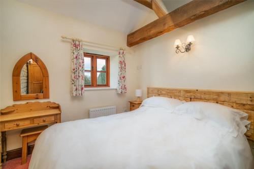 a bedroom with a large white bed and a desk at Carters cottage in Buckinghamshire