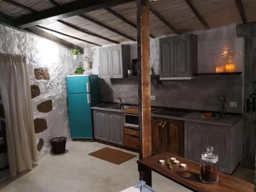 a kitchen with white cabinets and a blue refrigerator at La Bohemia (Tejeda) in Tejeda