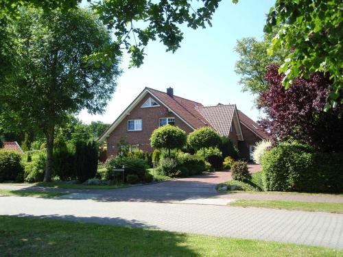 a brick house with a driveway in front of it at Ferienwohnung Haus Bikker in Ihlow