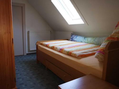 a small room with a bed in a attic at Ferienwohnung Ferienhaus Moorblick in Ihlow
