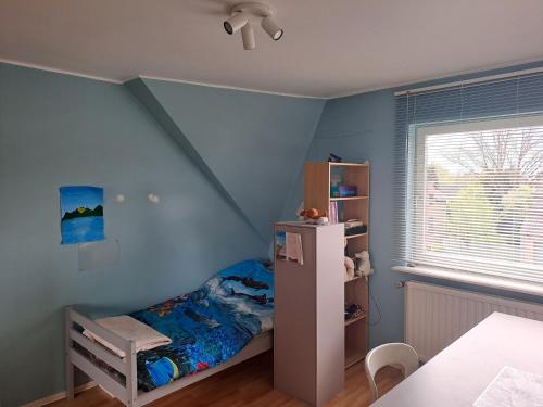 Habitación infantil con cama y pared azul en Sweet home, en Tervuren