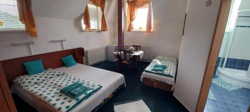a small room with two beds and a table at Penzión Stefanie in Vinné