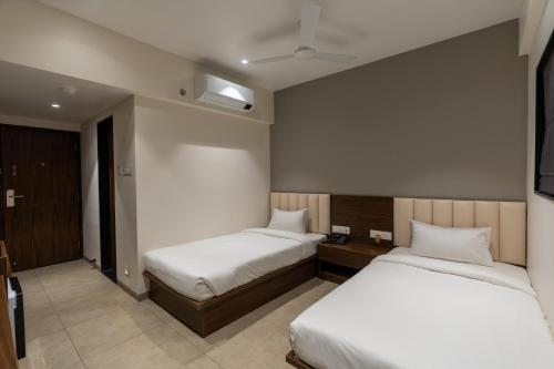 two beds in a room with two beds sidx sidx sidx sidx at The Living Hub Hotel, Kolhapur- Walkable From Central Bus Station in Kolhapur