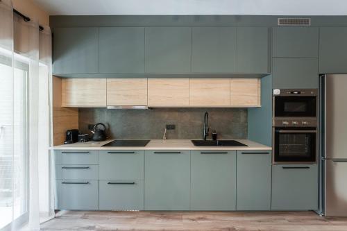 a kitchen with blue cabinets and white appliances at GuestReady - A breath of fresh air in Nogueiró in Nogueiro