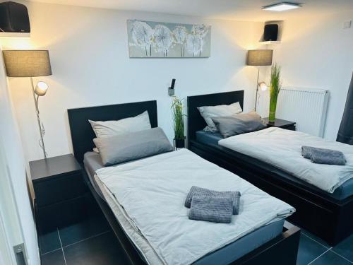 two beds in a room with white and blue at Blauer Stein Apartments Doppelzimmer 2 in Pulheim
