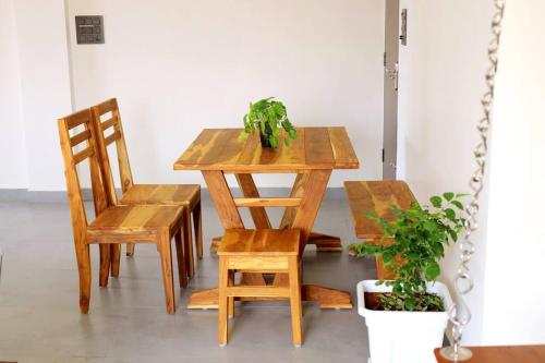 a wooden table and chairs with a plant on it at Eazy Homes in Palakkad