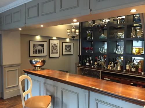 a bar with a wooden counter and a chair at Ingram House with Hot Tub in Hurst Green
