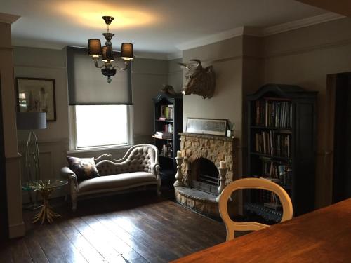 a living room with a couch and a fireplace at Ingram House with Hot Tub in Hurst Green
